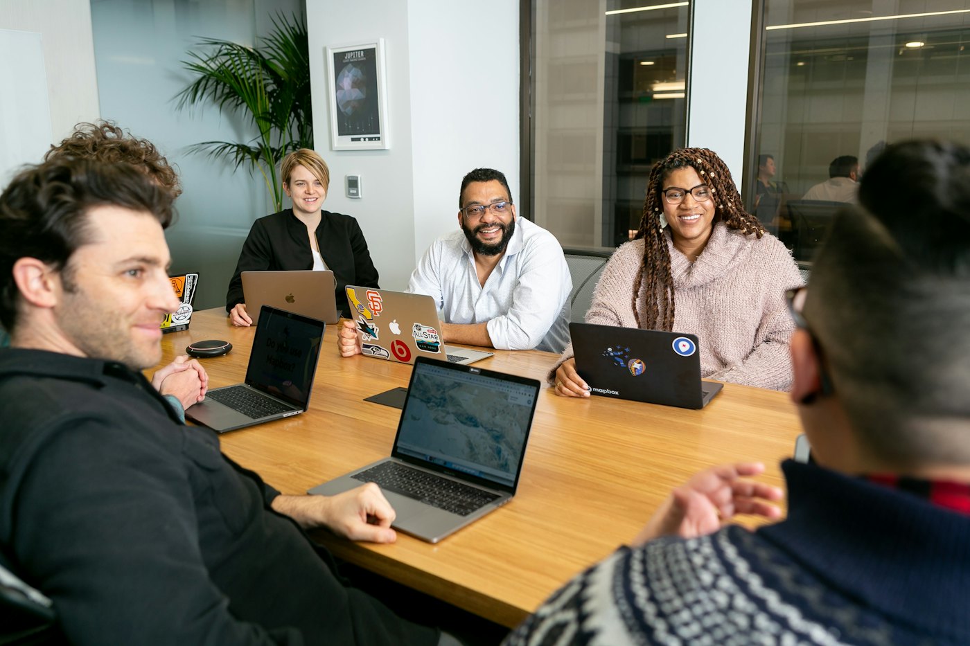 Diverse team meeting around a table with laptops